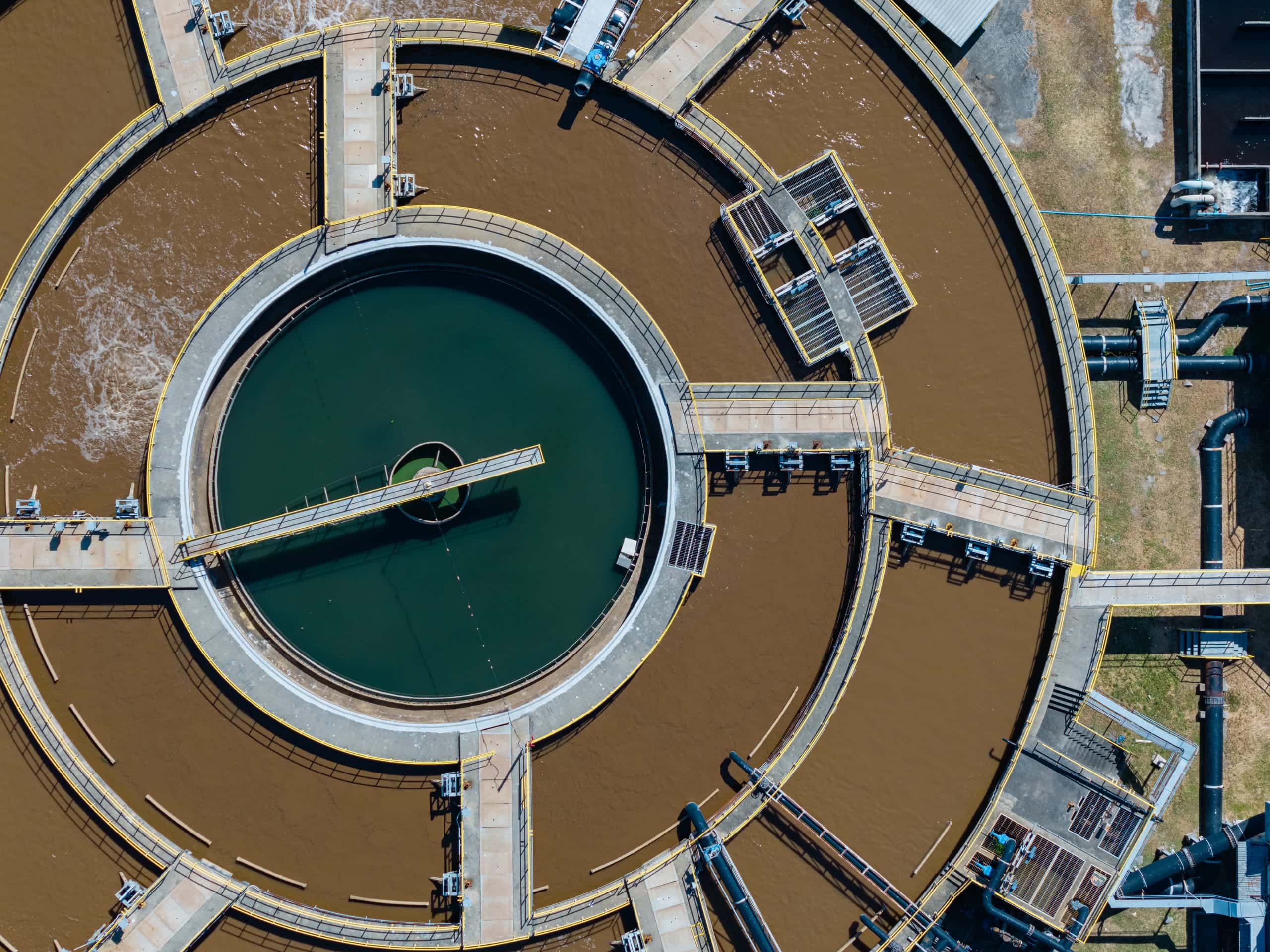 Aerial view of a wastewater treatment plant clarifier and oxidation basins
