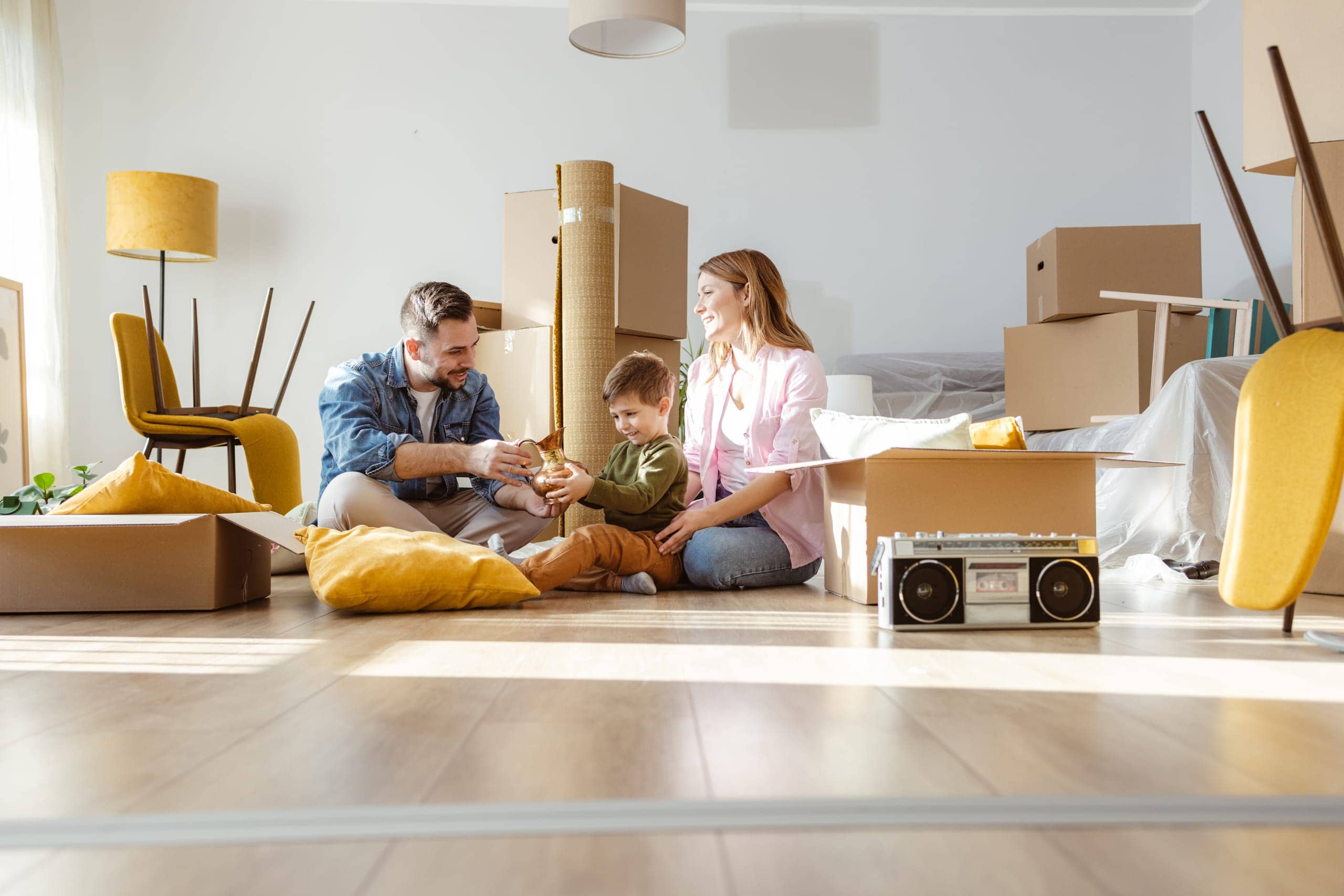 Family unpacking moving boxes in their new home