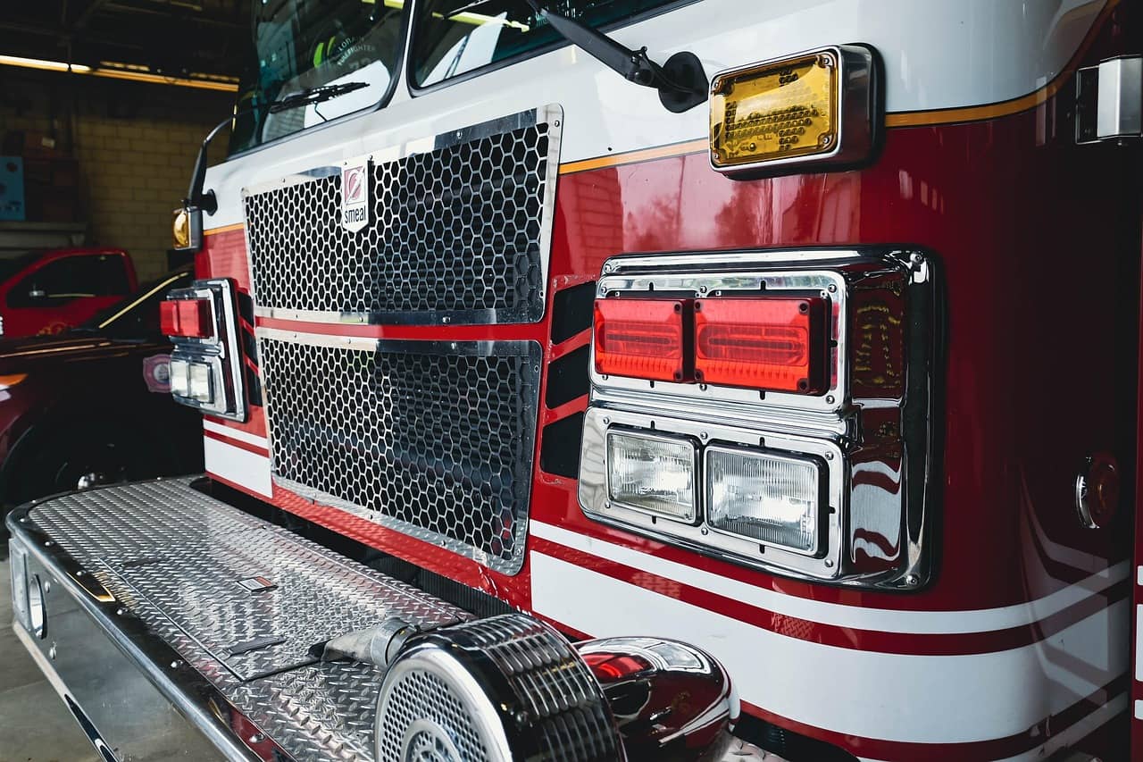 Volunteer firefighters beside an engine outside a rural fire station